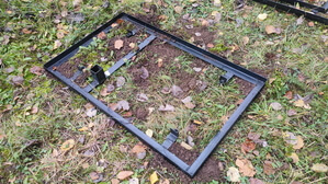 Стеклянный вертикальный памятник со скосом фон памятника под гранит, цветник в обрамлении гранитной брусчатки установка в металлической раме